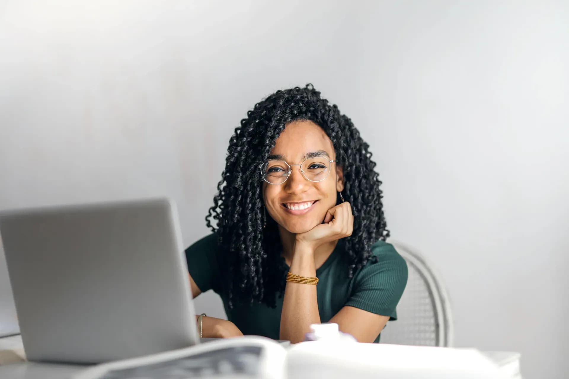 Happy woman smiling at her laptop, celebrating a small first AI win