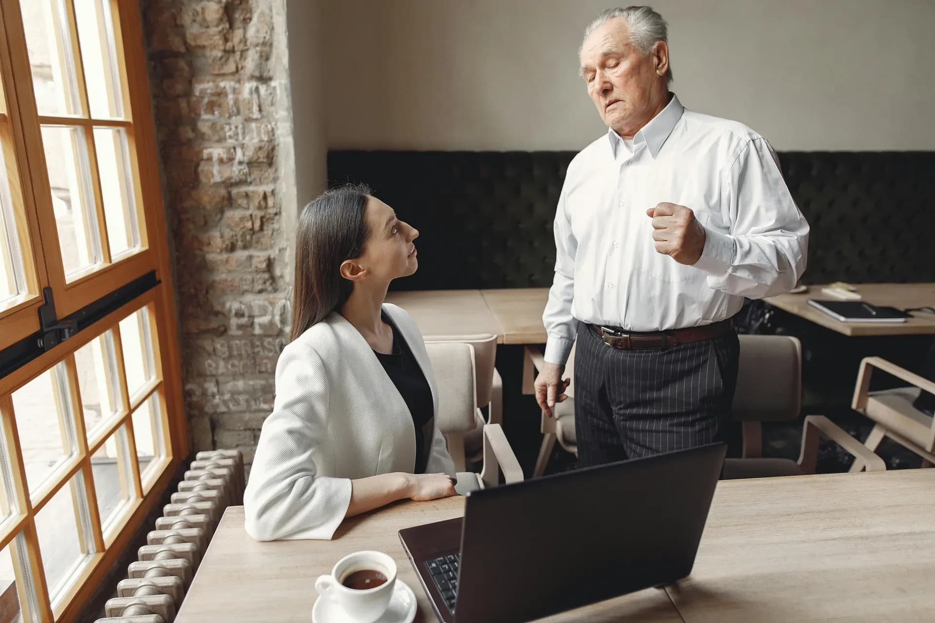 Two professionals in a serious one-on-one conversation in a warmly lit office